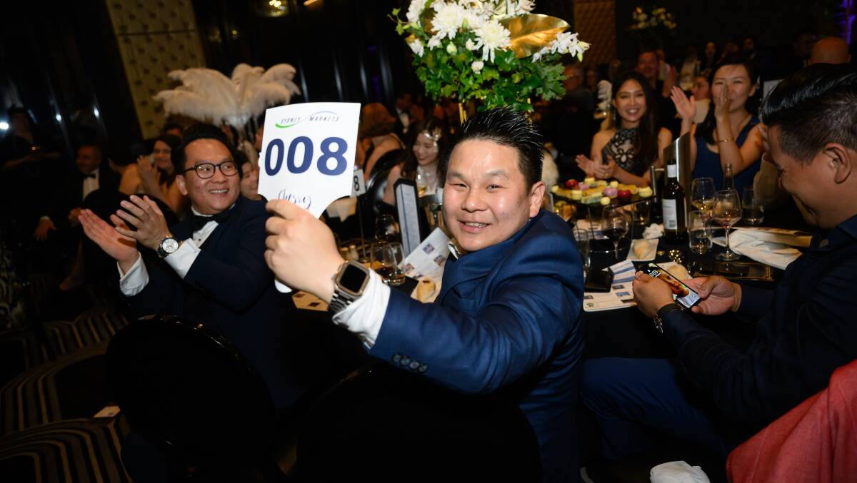 Robert Lo, Pro Bros Providore, Sydney lifts his bid to $60,000 to secure the symbolic first tray of cherries for the season at the Sydney Markets Foundation Annual Cherry Auction. Picture supplied 